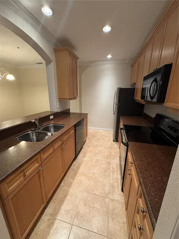 a kitchen with kitchen island granite countertop a sink and a stove top oven