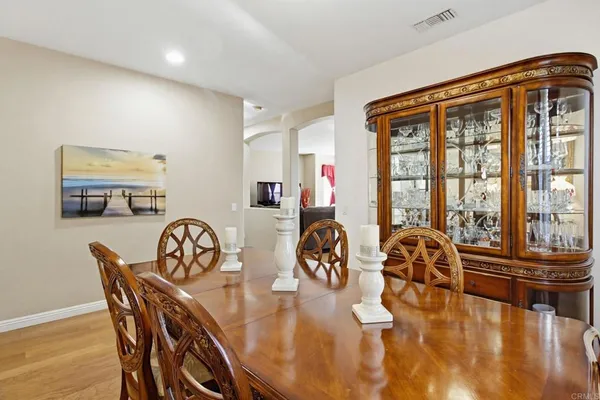 a dining room with furniture a chandelier and wooden floor