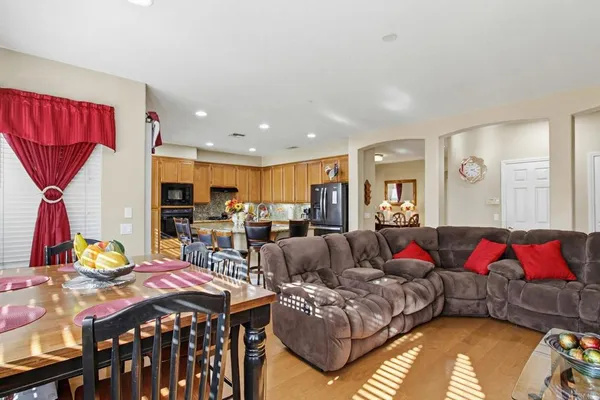 a living room with furniture kitchen view and a large window
