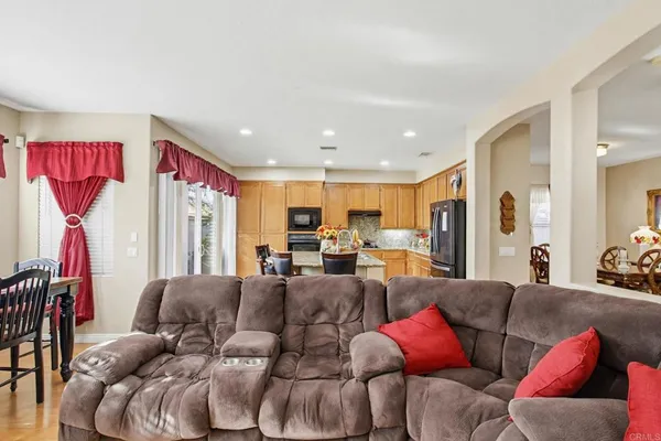 a living room with furniture kitchen view and a large window