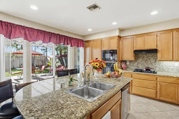 a kitchen with stainless steel appliances granite countertop a sink counter space cabinets and a large window