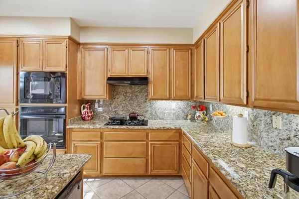 a kitchen with stainless steel appliances granite countertop a sink stove and cabinets