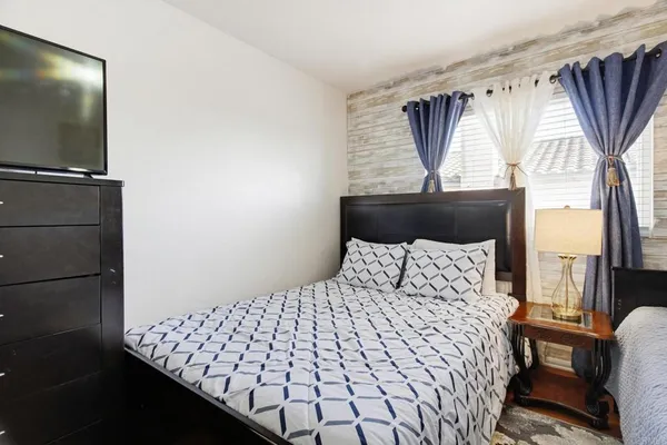 a bedroom with a bed and wooden floor
