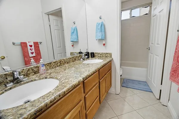 a bathroom with a granite countertop sink a mirror and a bathtub