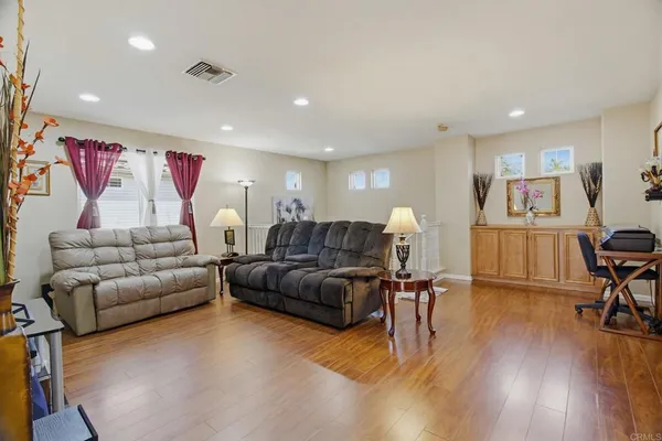 a living room with furniture and wooden floor
