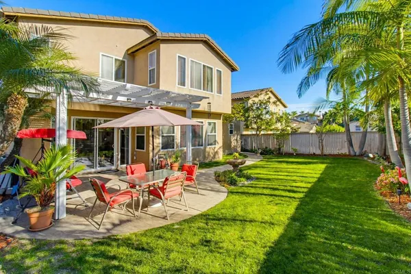 a front view of a house with garden and chairs