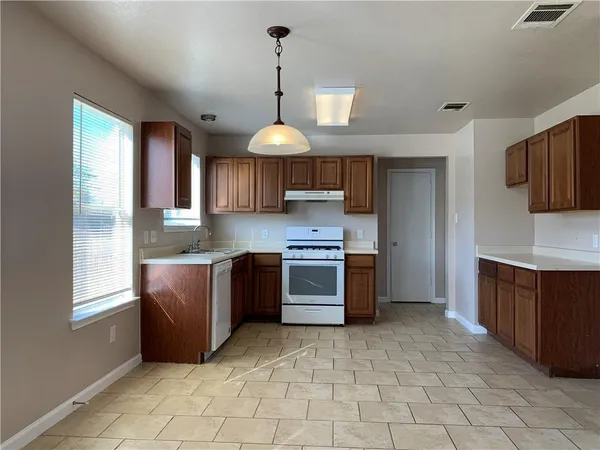 a kitchen with stainless steel appliances granite countertop a stove a sink dishwasher a refrigerator and a microwave oven