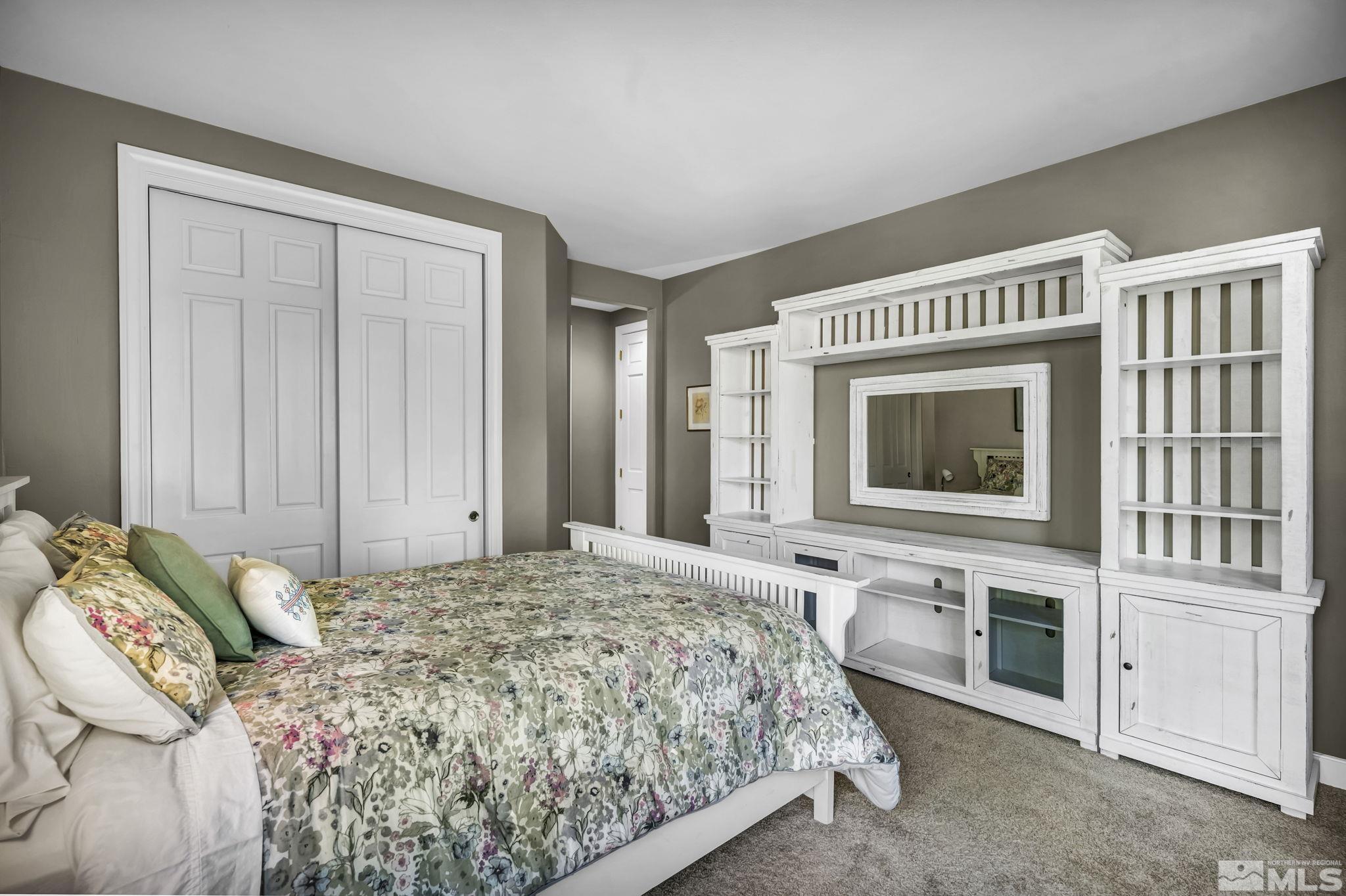 4277 Bitteroot Road Reno, NV 89519 - Photo 28 of 40 a spacious bedroom with a bed and a fireplace