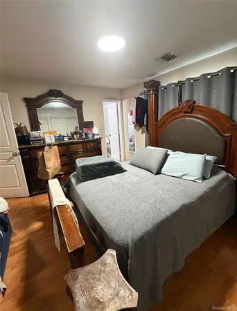 a bedroom with a bed and a mirror on the dresser