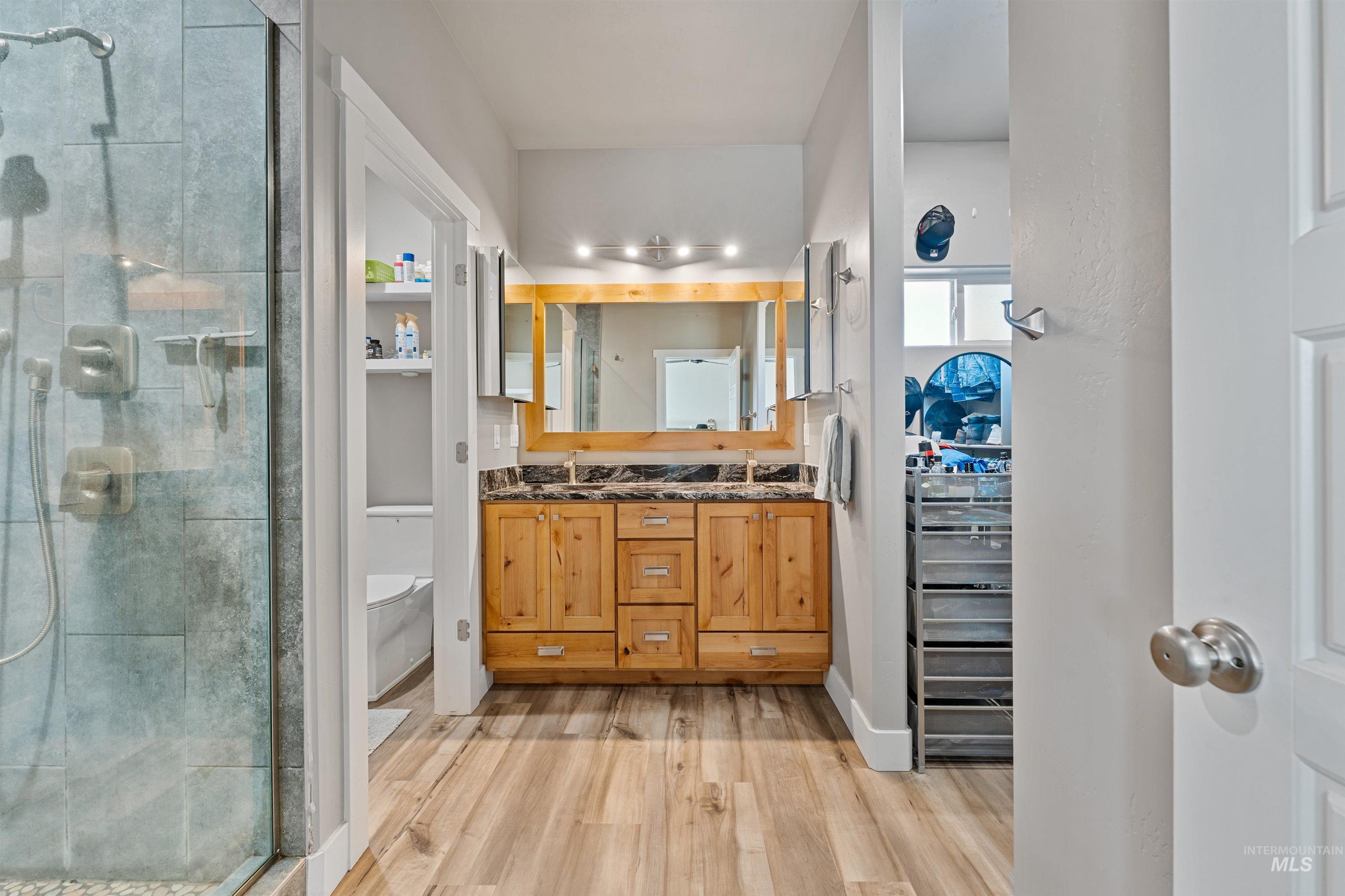 1005 Kenbrook Loop Twin Falls, ID 83301 - Photo 17 of 47 Bathroom with double vanity, a stall shower, and light wood finished floors