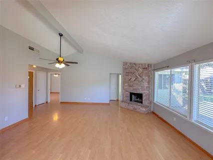 wooden floor fireplace and windows in an empty room