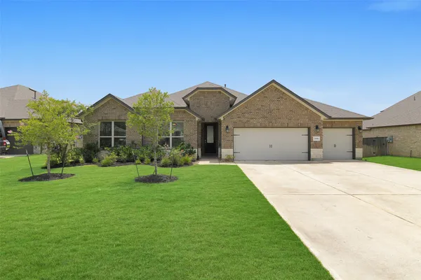 a front view of a house with a garden and yard