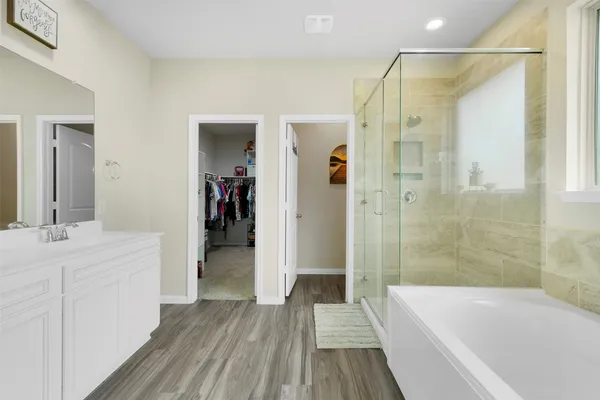 a bathroom with a bathtub a sink and a mirror