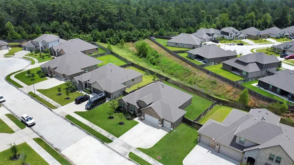 an aerial view of a house with a garden and lake view