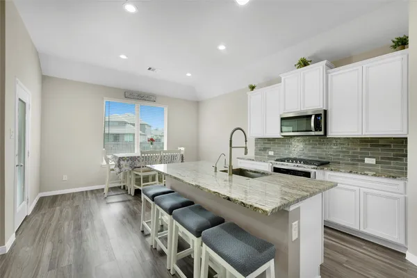 a kitchen with a sink a stove a microwave and cabinets