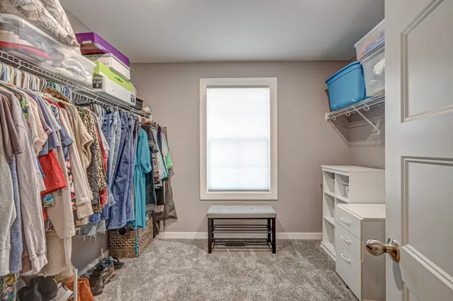 a dining room with wooden floor a chandelier a glass table and chairs