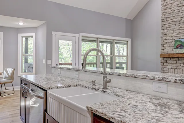 a bathroom with a granite countertop sink and a window