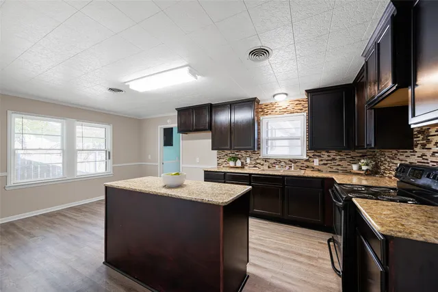 a kitchen with a stove sink and cabinets