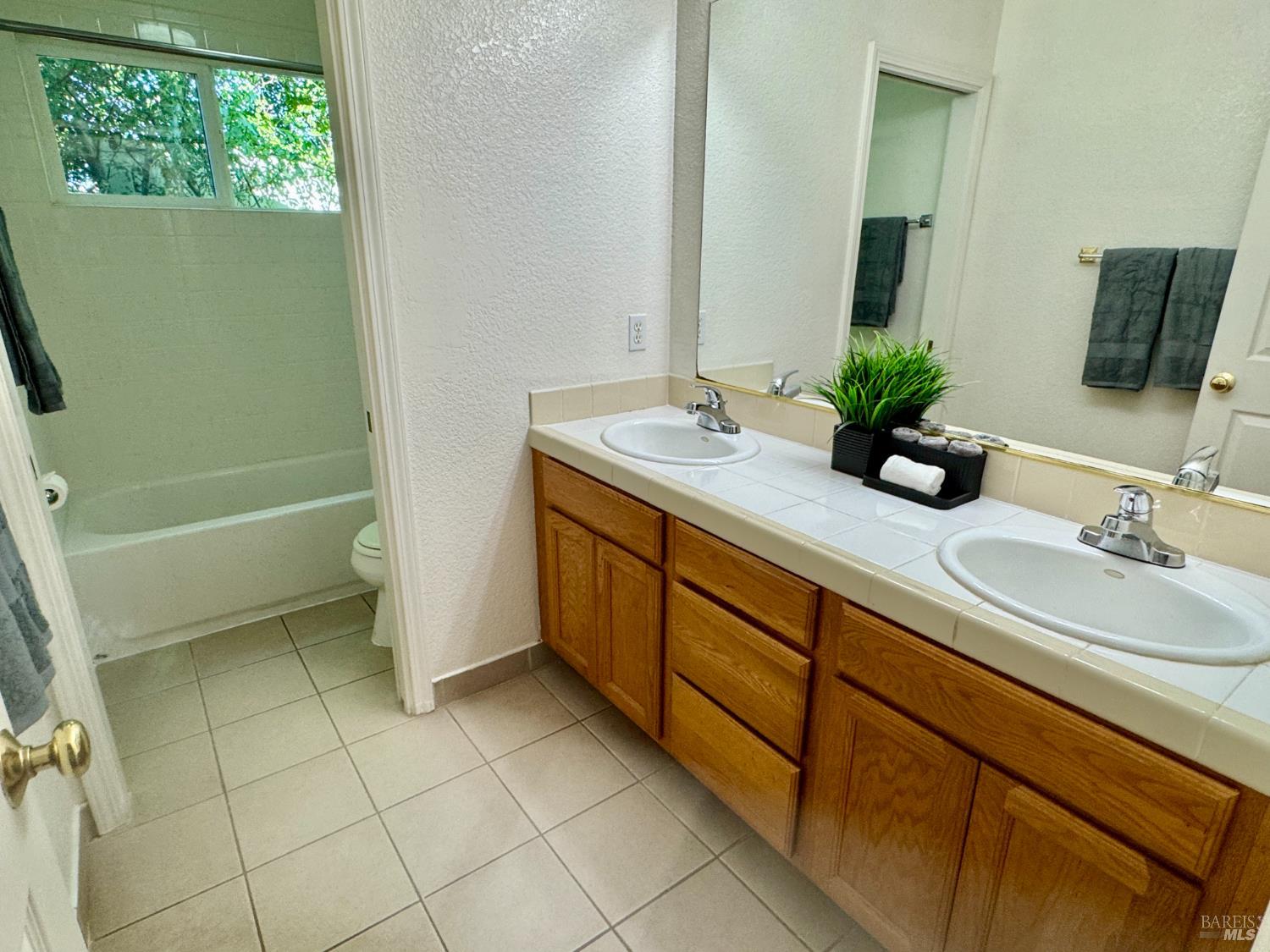 1836 Hearn Avenue Santa Rosa, CA 95407 - Photo 10 of 22 a bathroom with a double vanity sink a mirror and a bathtub