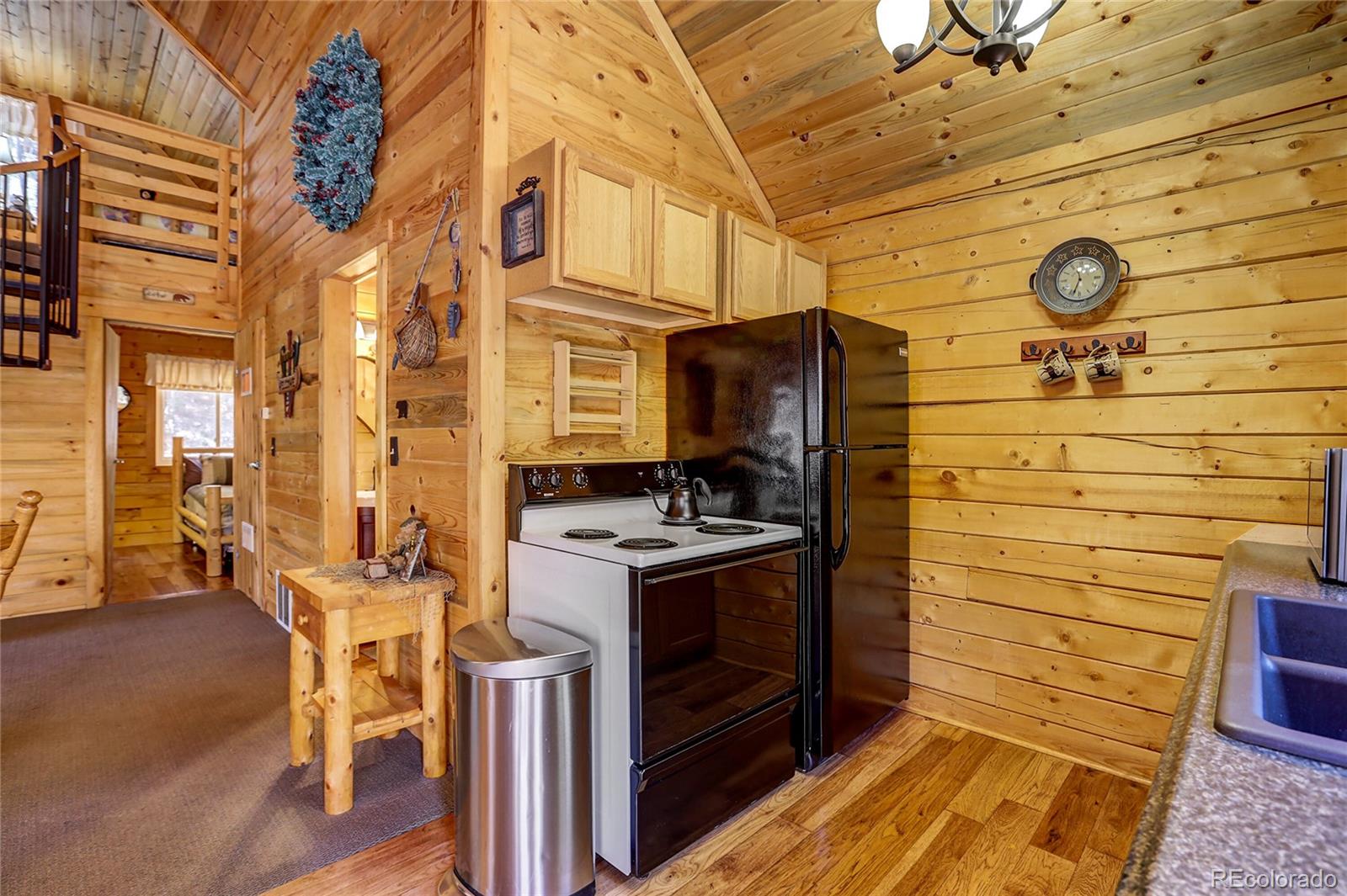 7721 County Road 43 Bailey, CO 80421 - Photo 26 of 49 a kitchen with stainless steel appliances kitchen island granite countertop a stove and a refrigerator