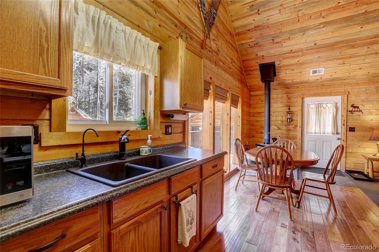 7721 County Road 43 Bailey, CO 80421 - Photo 27 of 49 a kitchen with stainless steel appliances a sink a stove and wooden floors