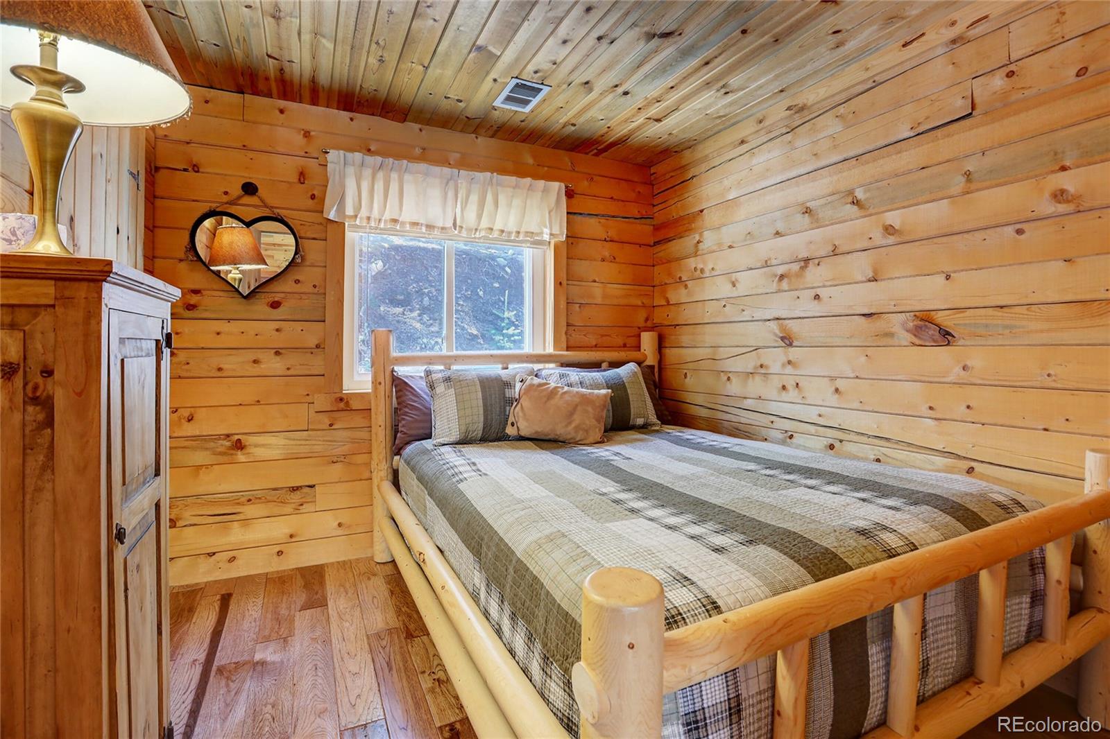 7721 County Road 43 Bailey, CO 80421 - Photo 30 of 49 a bedroom with a bed and a wooden floor