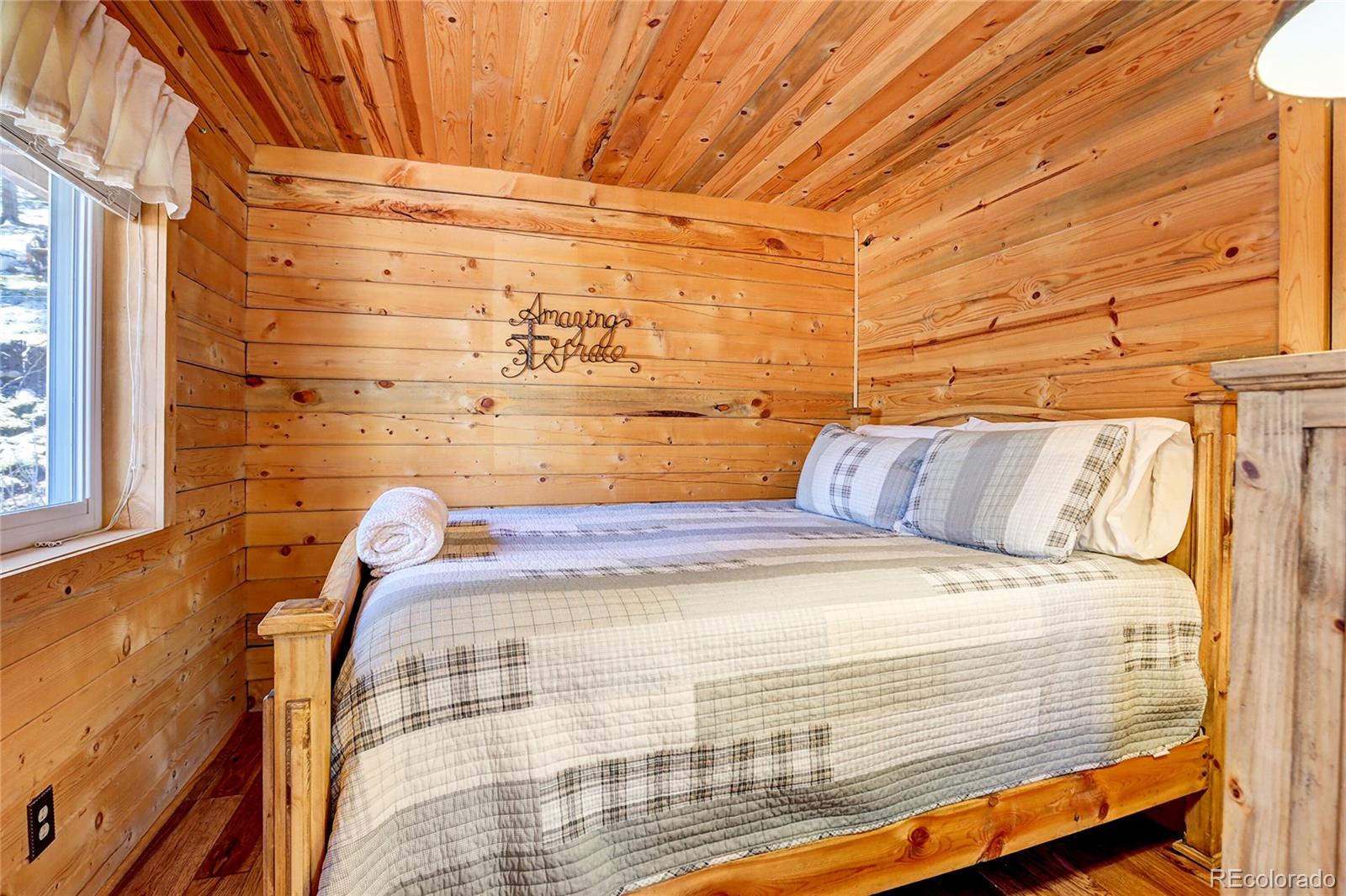 7721 County Road 43 Bailey, CO 80421 - Photo 36 of 49 a bed sitting in a bedroom next to a window