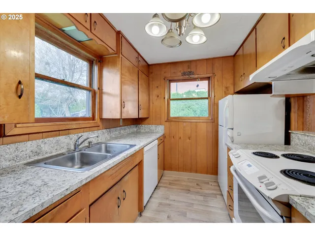 a kitchen that has a sink a stove and a window