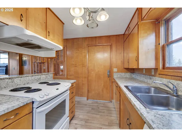 a kitchen that has a sink a stove and a microwave oven