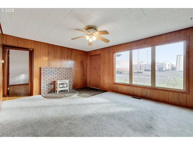 a view of an empty room with a fireplace and a window