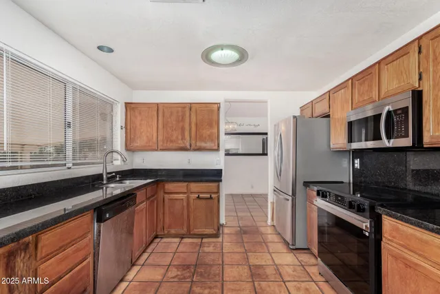 a kitchen with stainless steel appliances a sink stove and cabinets
