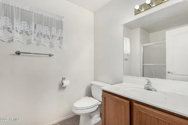 a bathroom with a granite countertop sink toilet and a mirror