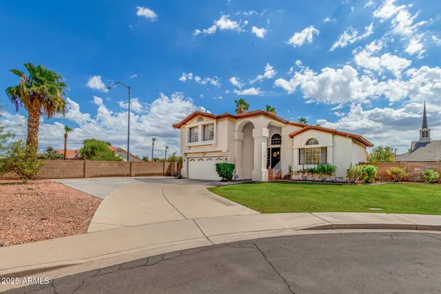 a view of a white house with a yard and potted plants