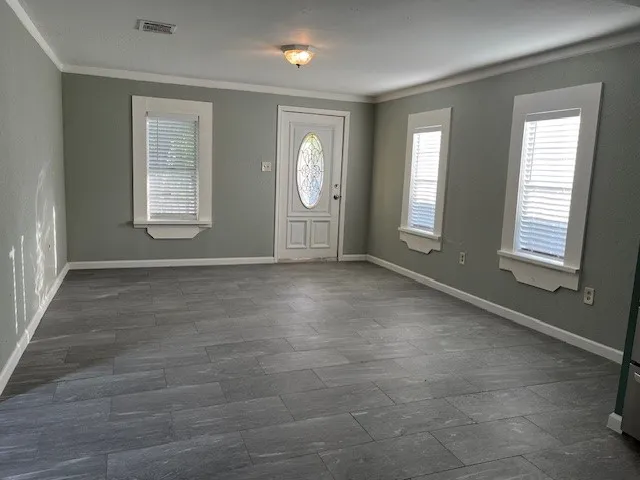 a view of an empty room with window and bathroom