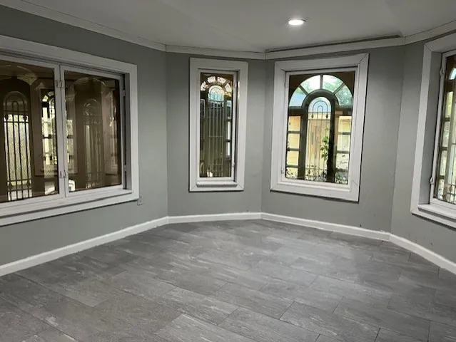 an empty room with windows and chandelier