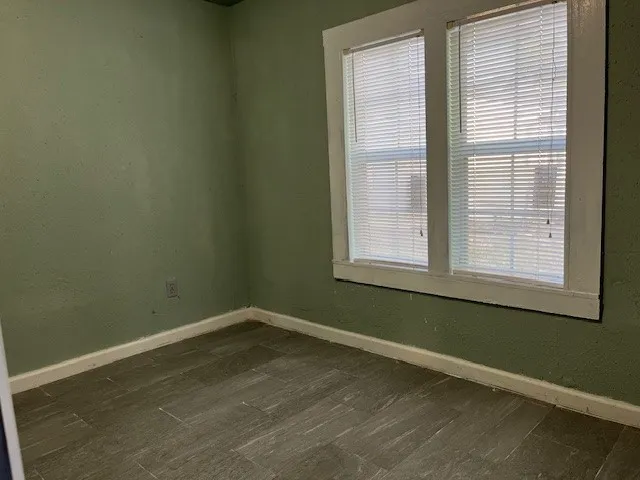 a view of a room with wooden floor and windows