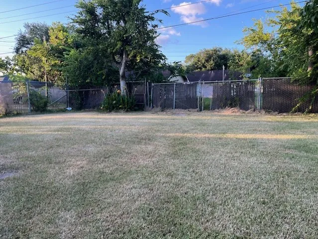 a view of a backyard with wooden fence
