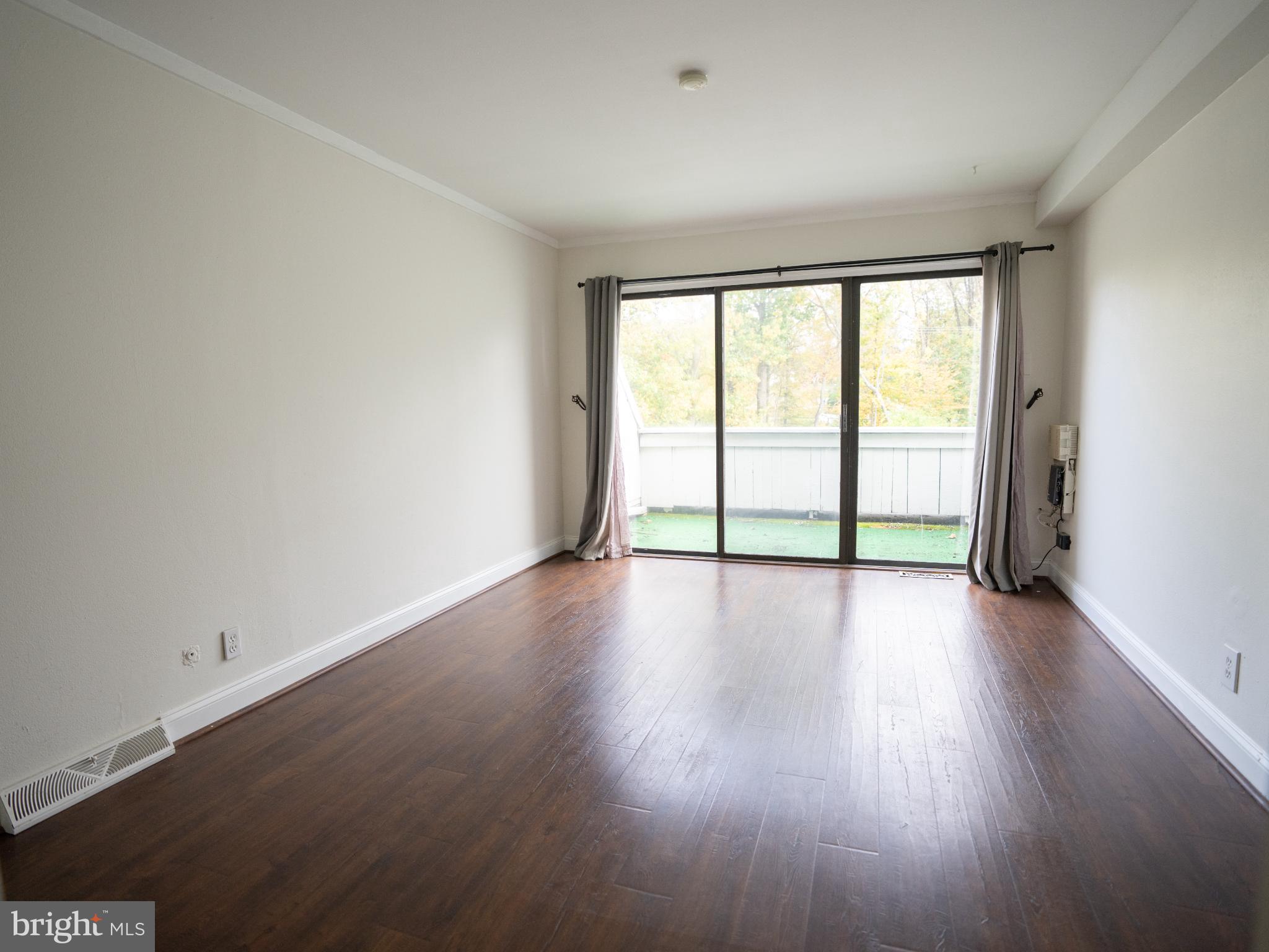573 Summit House West Chester, PA 19382 - Photo 11 of 20 a view of an empty room with wooden floor and a window