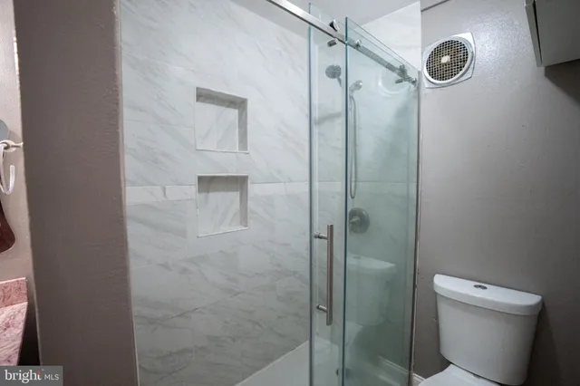 a bathroom with a shower a toilet and a sink