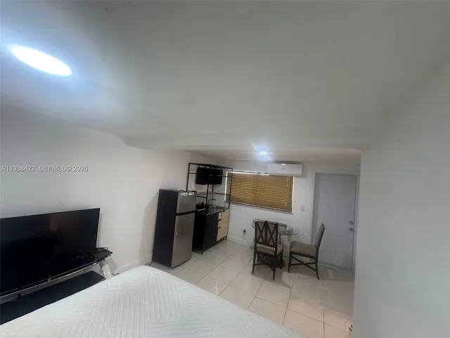 a living room with furniture a flat screen tv and kitchen view