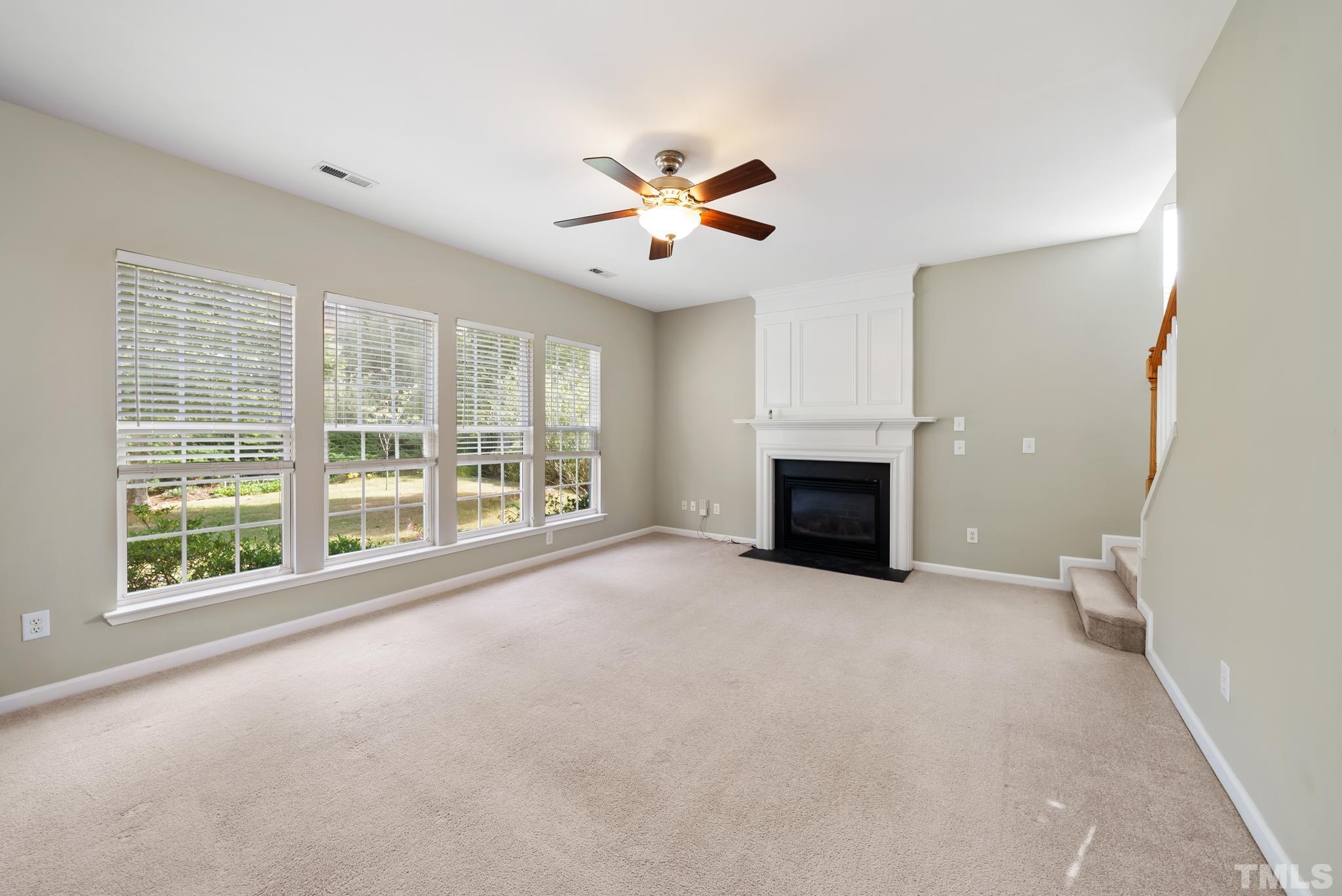 7432 Silver View Lane Raleigh, NC 27613 - Photo 11 of 28 a view of an empty room with chandelier fan and a fireplace