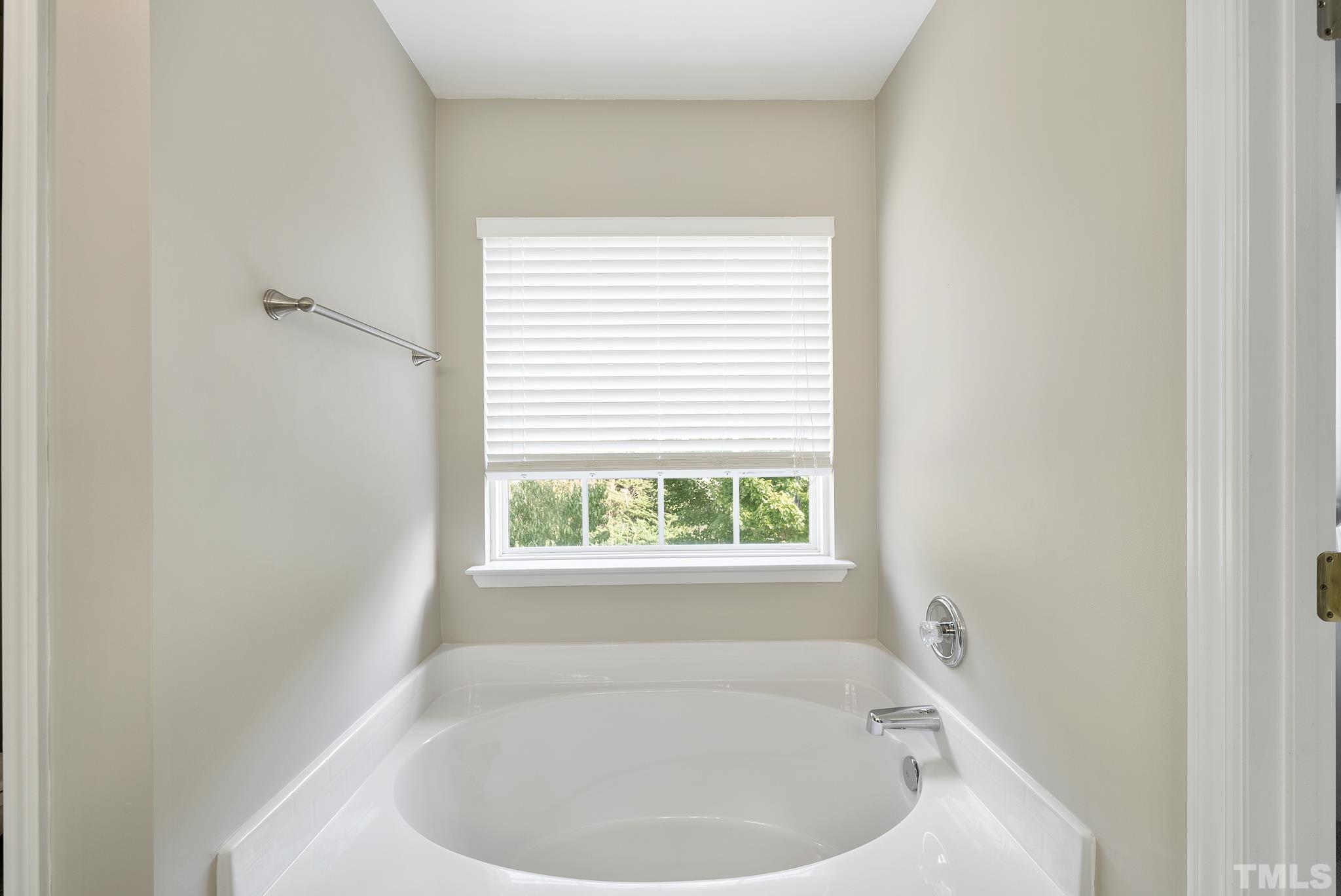 7432 Silver View Lane Raleigh, NC 27613 - Photo 17 of 28 a white bath tub sitting in a bathroom next to a window