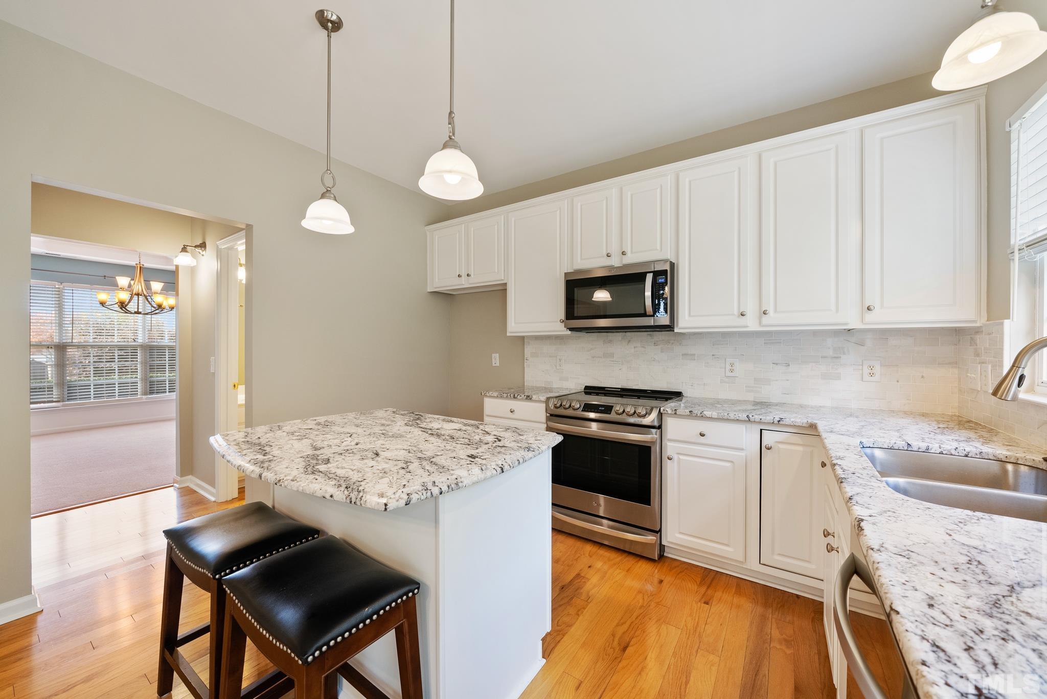 7432 Silver View Lane Raleigh, NC 27613 - Photo 8 of 28 a kitchen with a stove a sink and a refrigerator