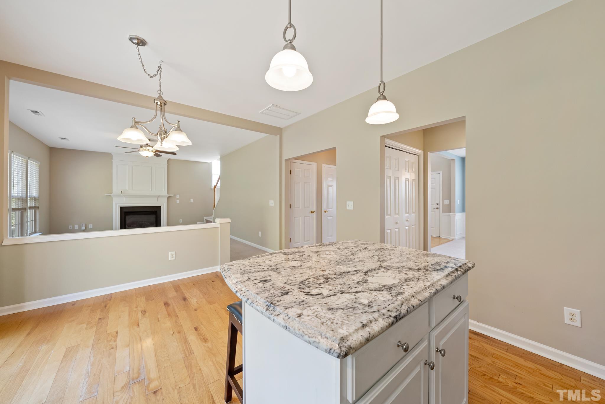 7432 Silver View Lane Raleigh, NC 27613 - Photo 9 of 28 a kitchen with kitchen island a chandelier and living room