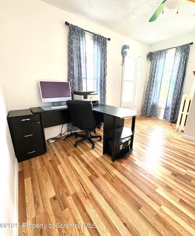 a view of a workspace with furniture and a window