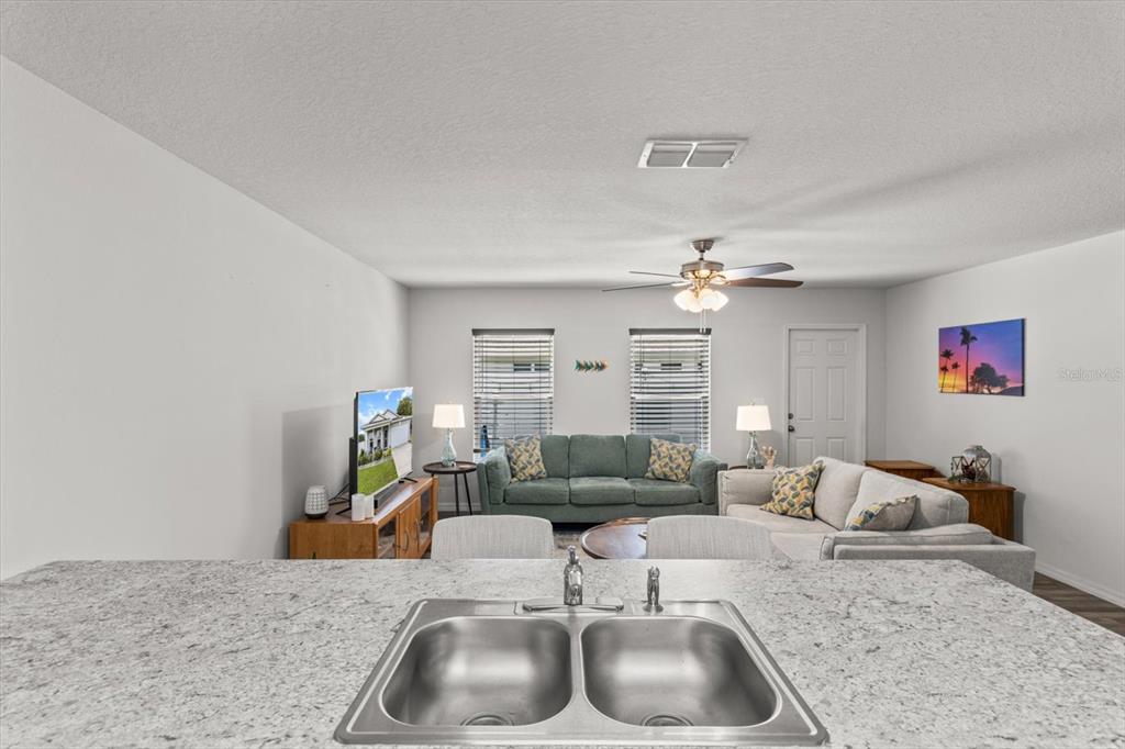 3332 Lambert Avenue Spring Hill, FL 34608 - Photo 12 of 30 a living room with furniture and a chandelier