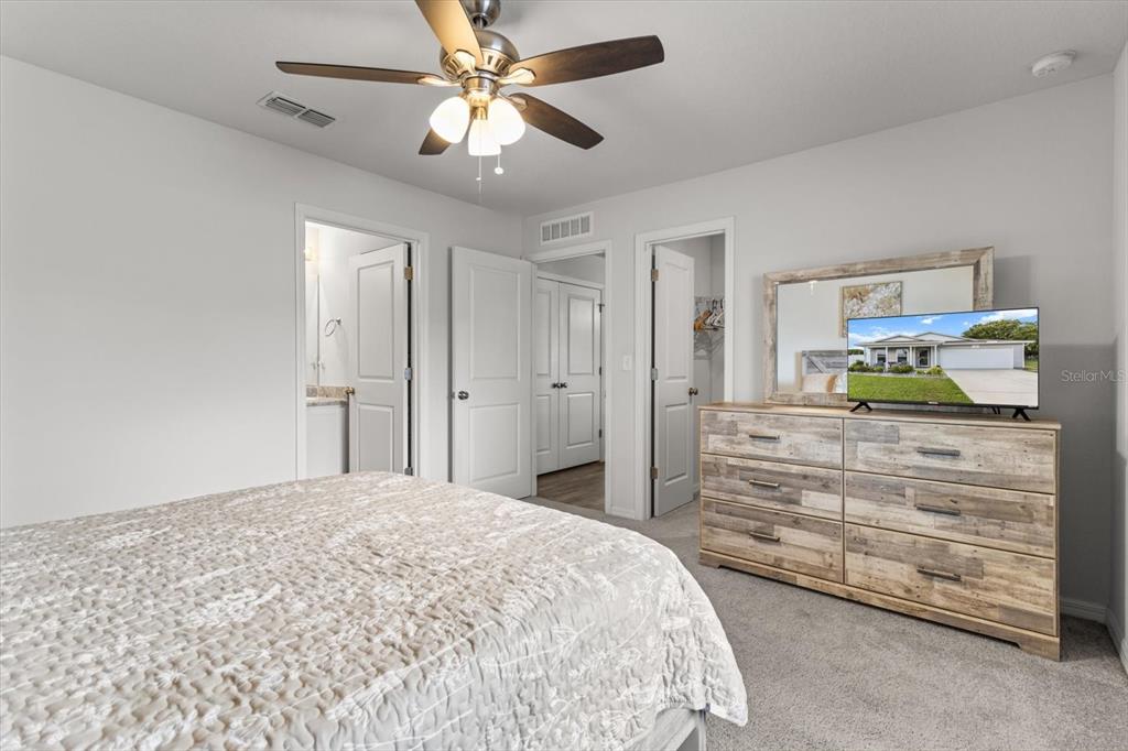 3332 Lambert Avenue Spring Hill, FL 34608 - Photo 14 of 30 a bedroom with a bed and a chandelier