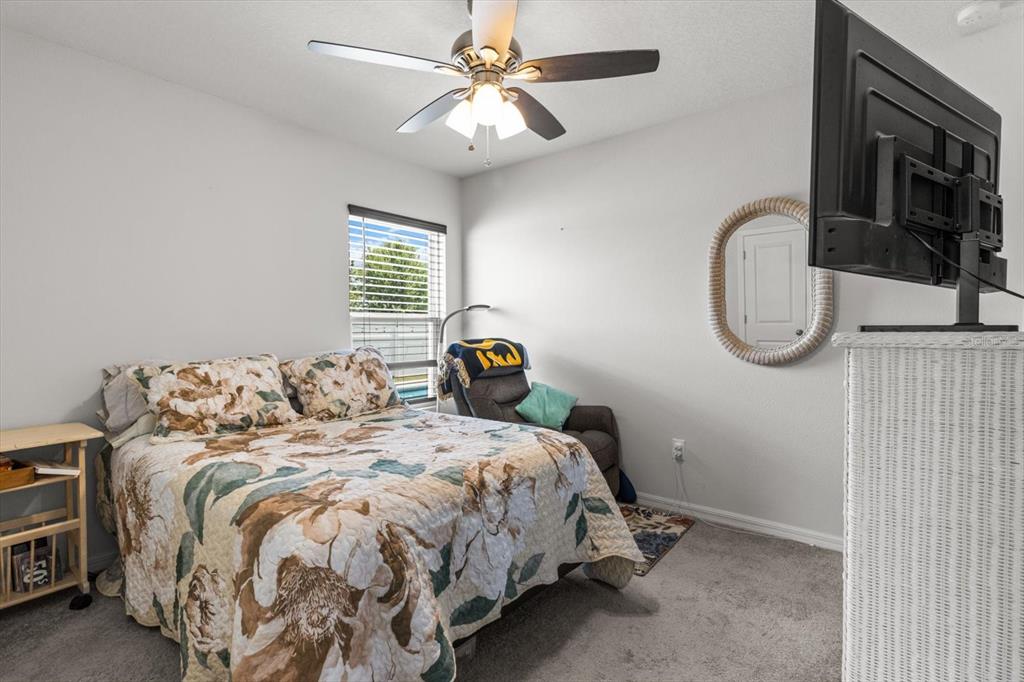 3332 Lambert Avenue Spring Hill, FL 34608 - Photo 17 of 30 a bedroom with a bed and a chandelier