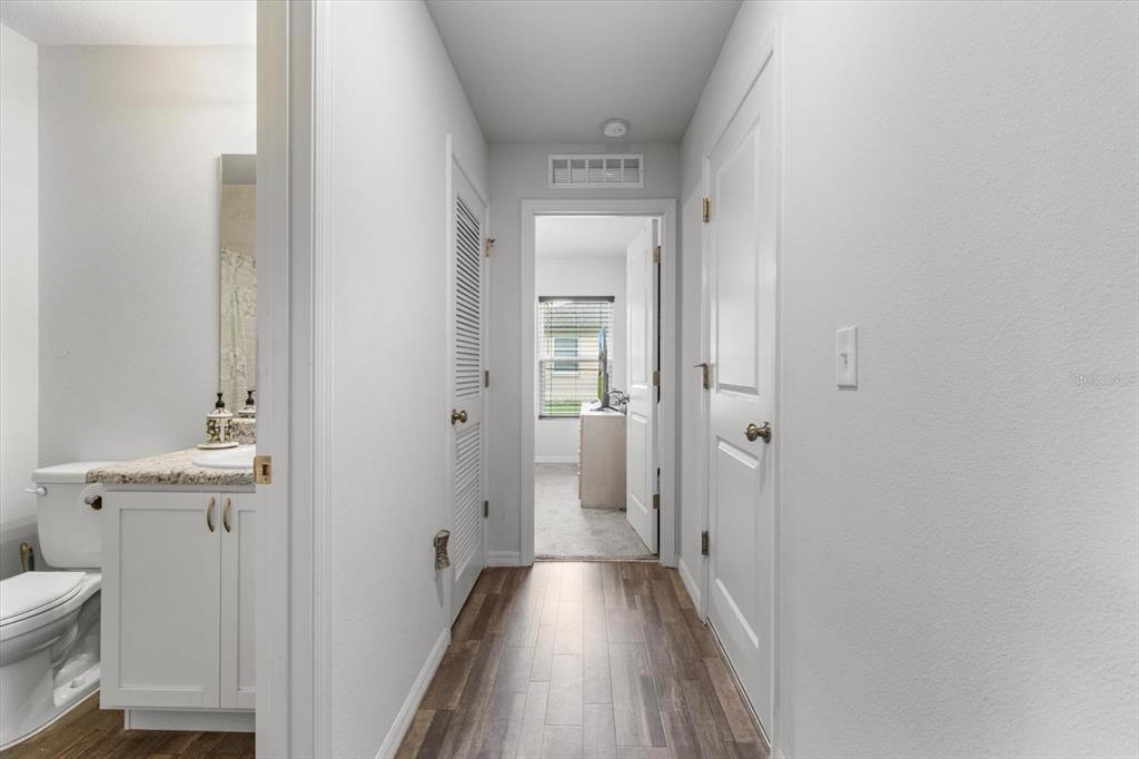 3332 Lambert Avenue Spring Hill, FL 34608 - Photo 19 of 30 a view of a hallway with wooden floor and a bathroom