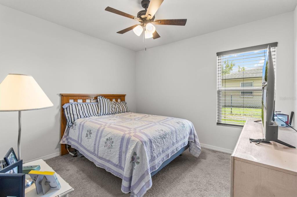 3332 Lambert Avenue Spring Hill, FL 34608 - Photo 21 of 30 a bedroom with a bed and a chandelier